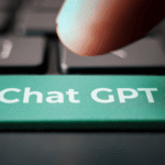 Dedo apertando tecla com de um teclado com o botão verde escrito Chat GPT.
